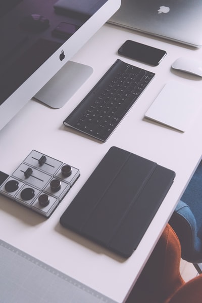 黑色iPad手机壳、苹果无线键盘、iMac在白色桌面上的平面摄影